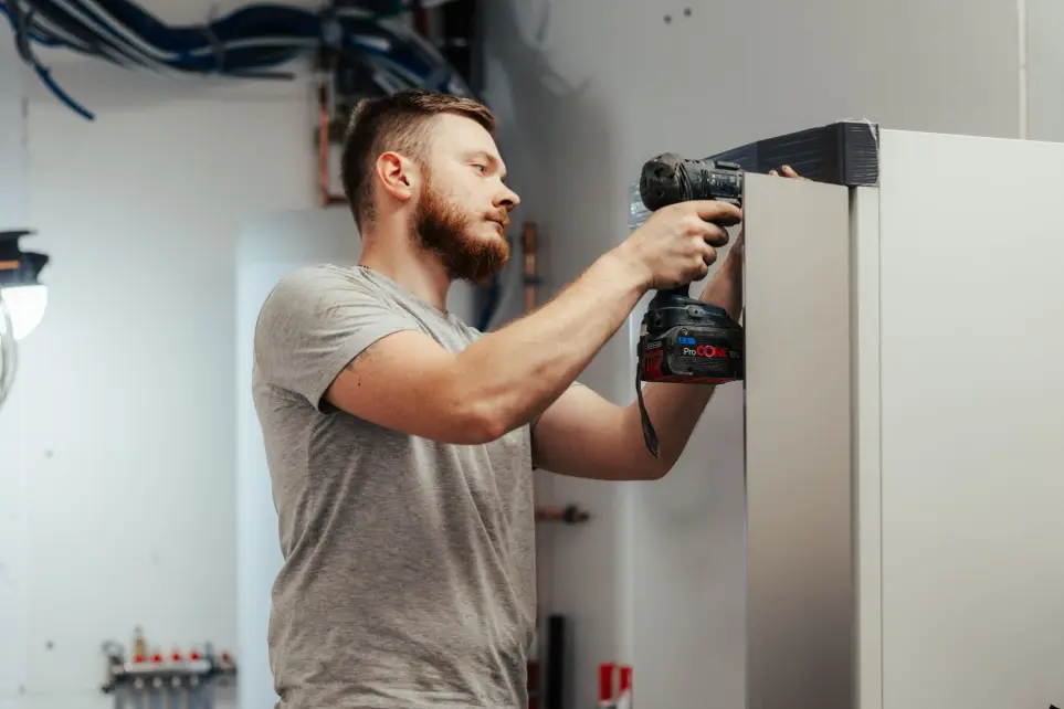 installateur sluit warmtepomp binnen in de woning aan